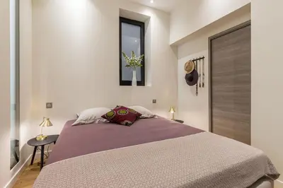 a bedroom with a large bed and a window at Cosy Cocoon Place du Pin in Nice
