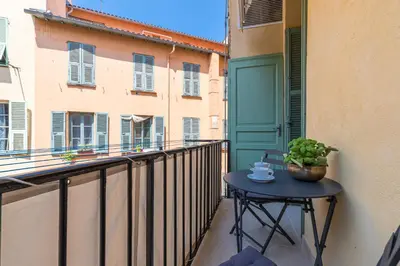 a small table on a balcony with a cup of coffee at Cosy Cocoon Place du Pin in Nice