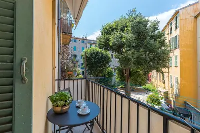 a table on a balcony with a view of a street at Cosy Cocoon Place du Pin in Nice