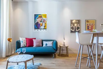 a living room with a blue couch and a table at Refined & Cozy 1 Bedroom Downtown in Nice