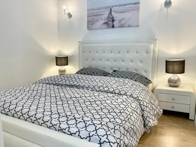 a white bedroom with a white bed with two lamps at LAMARTINE- Heart of Center- Modern and Design flat in Nice