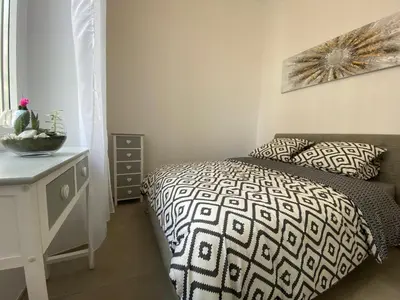 a bedroom with a black and white bed and a table at ZEN and Charming - Center -5 min walk to Sea- 2BR in Nice