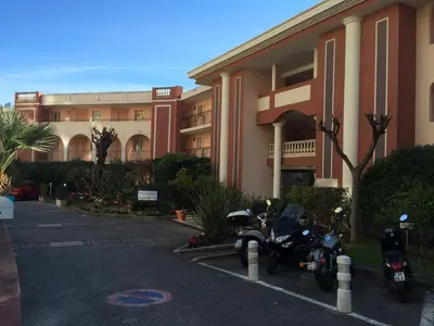 two motorcycles parked in a parking lot in front of a building at Appartement Ange Gardien Vue Mer in Villefranche-sur-Mer