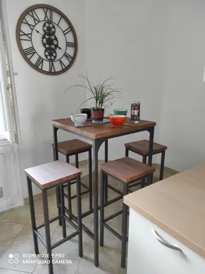a kitchen table with stools and a clock on the wall at Pretty and quiet top floor 2 bedroom flat in the port area of Nice in Nice