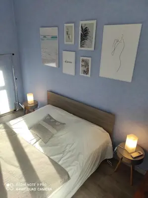 a bedroom with a bed and some pictures on the wall at Pretty and quiet top floor 2 bedroom flat in the port area of Nice in Nice