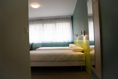 a bedroom with two beds and a mirror at PARME ETAPE in Nice