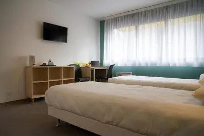 a hotel room with two beds and a television at PARME ETAPE in Nice