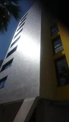 a tall white building with windows and a blue sky at PARME ETAPE in Nice