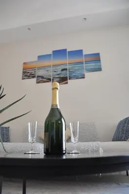 a bottle of wine sitting on a table with two glasses at Silver Beach Central 4pers Séjour 30jours Location éligible au Bail Mobilité Mobility Lease in Nice