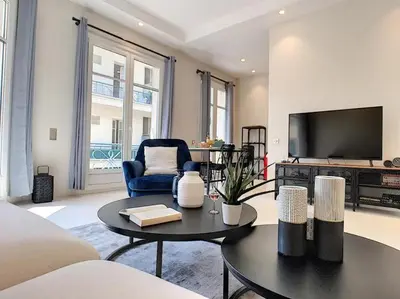 a living room with a tv and a blue chair at Silver Beach Central 4pers Séjour 30jours Location éligible au Bail Mobilité Mobility Lease in Nice