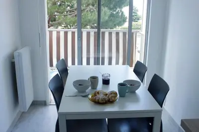 a white table with chairs and a bowl of food on it at Azur 3000 in Saint-Laurent-du-Var
