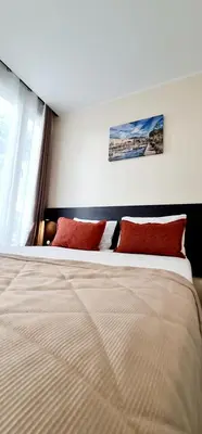 a bedroom with a large bed with red pillows at Evelia Hotels in Nice