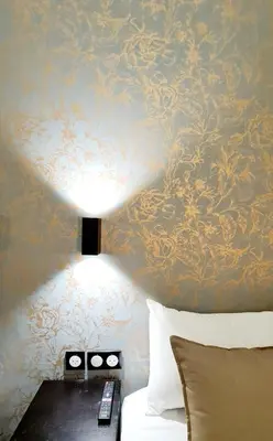 a room with a bed and a lamp on a wall at Evelia Hotels in Nice