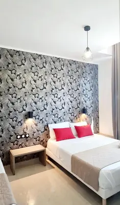 a bedroom with a bed and a wall with flowers at Evelia Hotels in Nice