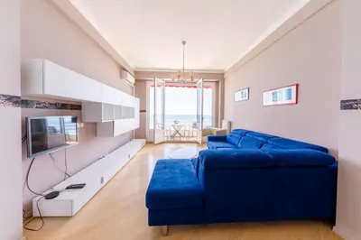 a living room with a blue couch and a tv at Wonderful Apartment on Sea in Nice