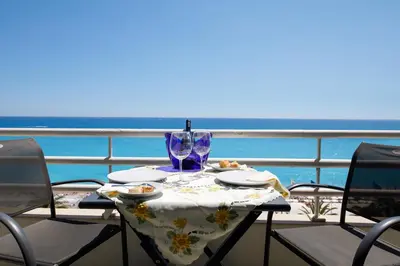 a table with a wine glass sitting on top of a balcony at Wonderful Apartment on Sea in Nice