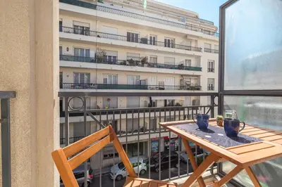 a balcony with a table and chairs and a building at Comfortable 1 Bdr Downtown - AC & Parking in Nice