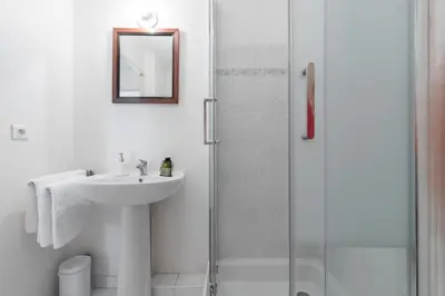 a white bathroom with a sink and a shower at Comfortable 1 Bdr Downtown - AC & Parking in Nice