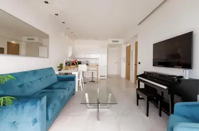 a living room with a blue couch and a piano at Sea view - Promenade des Anglais in Nice