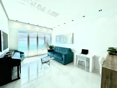 a living room with a blue couch and a table at Sea view - Promenade des Anglais in Nice