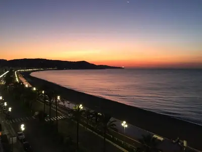 a view of a beach at night with lights at Appartement Front de Mer - Promenade des Anglais in Nice