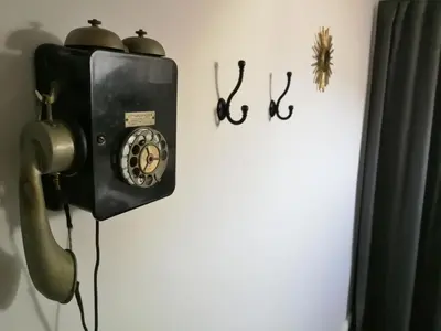 an old fashioned telephone is hanging on a wall at COCOON LOFT - MAGNIFIQUE LOFT SOUS TOIT, REFAIT A NEUF, VUES SPLENDIDES, CLIM, WIFi in Nice