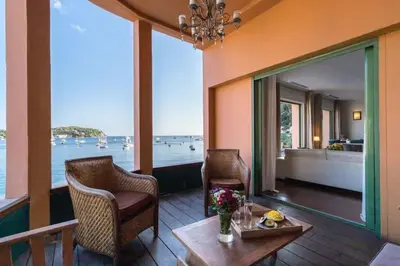 a room with a table and chairs and a view of the water at MY CASA - MARINIÈRES - Incredible view over the Bay in Villefranche-sur-Mer
