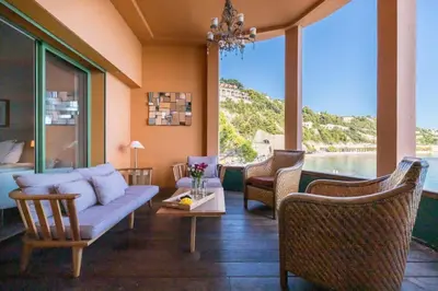 a living room with a couch and chairs and windows at MY CASA - MARINIÈRES - Incredible view over the Bay in Villefranche-sur-Mer