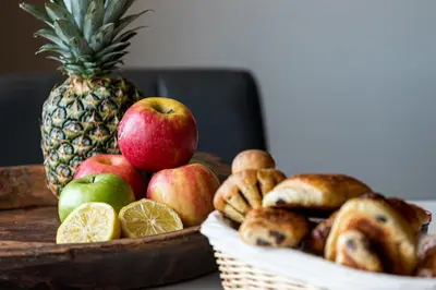 a table with apples oranges and bread and a pineapple at MY CASA - MARINIÈRES - Incredible view over the Bay in Villefranche-sur-Mer