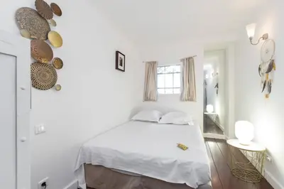 a white bedroom with a bed and a window at MY CASA - MARINIÈRES - Incredible view over the Bay in Villefranche-sur-Mer