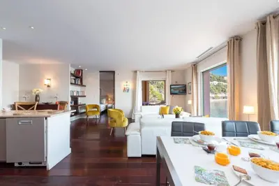 a kitchen and living room with a table and a couch at MY CASA - MARINIÈRES - Incredible view over the Bay in Villefranche-sur-Mer