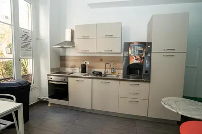 a kitchen with white cabinets and a sink at Le Pastoral in Nice