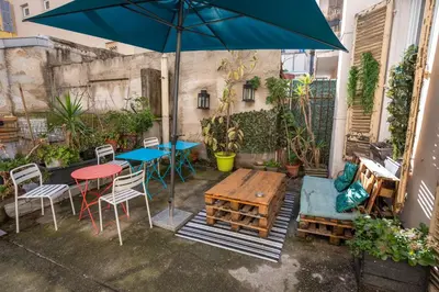 a patio with a table and chairs and an umbrella at Le Pastoral in Nice