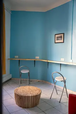 two chairs and a table in front of a blue wall at Le Pastoral in Nice