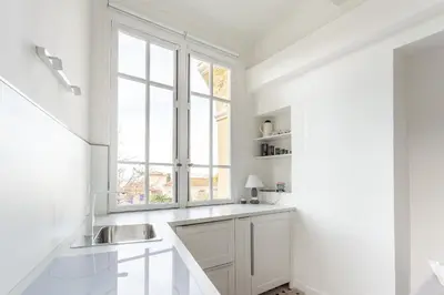 a white kitchen with a sink and a window at Seaside Studio by iCasamia it in Nice