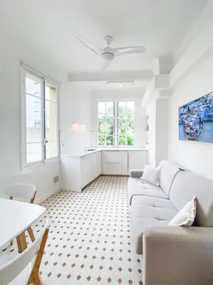 a white living room with a couch and a table at Seaside Studio by iCasamia it in Nice