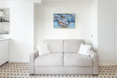 a couch in a living room with a picture on the wall at Seaside Studio by iCasamia it in Nice