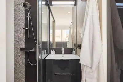 a bathroom with a sink and a shower with a mirror at Sunlight Properties - Sky blue - 3 bedroom flat with sea view on the Promenade des Anglais in Nice