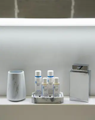a shelf with four bottles of medicines and a box at Sunlight Properties - Sky blue - 3 bedroom flat with sea view on the Promenade des Anglais in Nice