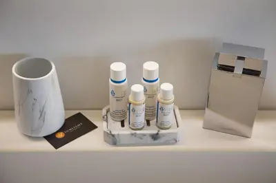 a shelf with a group of bottles and a cup at Sunlight Properties - Sky blue - 3 bedroom flat with sea view on the Promenade des Anglais in Nice