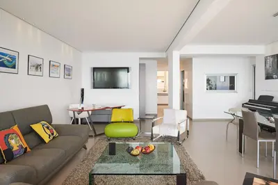 a living room with a couch and a table at Sunlight Properties - Sky blue - 3 bedroom flat with sea view on the Promenade des Anglais in Nice