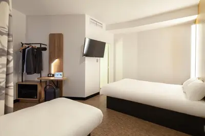 a hotel room with two beds and a tv at B&B HOTEL Nice Aéroport Arenas in Nice