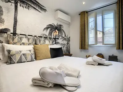 a bedroom with a large white bed with towels on it at Nestor&Jeeves - LOU FRANCESCAN - Old Town - Close sea - Place St Francois in Nice