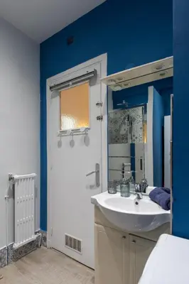 a bathroom with a white sink and a blue wall at 26 nice , La Riviera in Nice