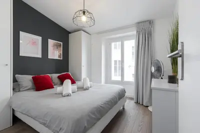 a white bedroom with a large bed with red pillows at Magenta Square Central 1 Bdr with AC in Nice