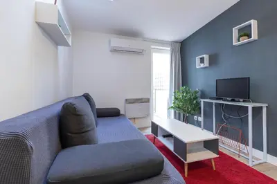 a living room with a couch and a tv at Magenta Square Central 1 Bdr with AC in Nice