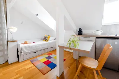a small white kitchen with a small table and a bed at Studio on the Attic 3min from the Sea & Main street in Nice