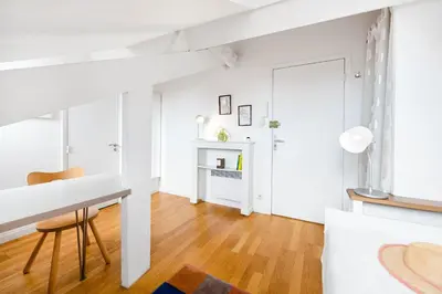 a white living room with a table and a chair at Studio on the Attic 3min from the Sea & Main street in Nice