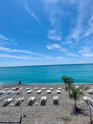 a row of lounge chairs on a beach with the ocean at Studio on the Attic 3min from the Sea & Main street in Nice