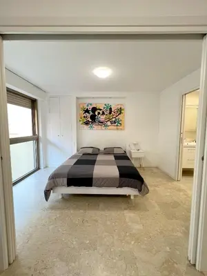 a bedroom with a bed and a painting on the wall at Petit 2 pièces Carré d'Or in Nice